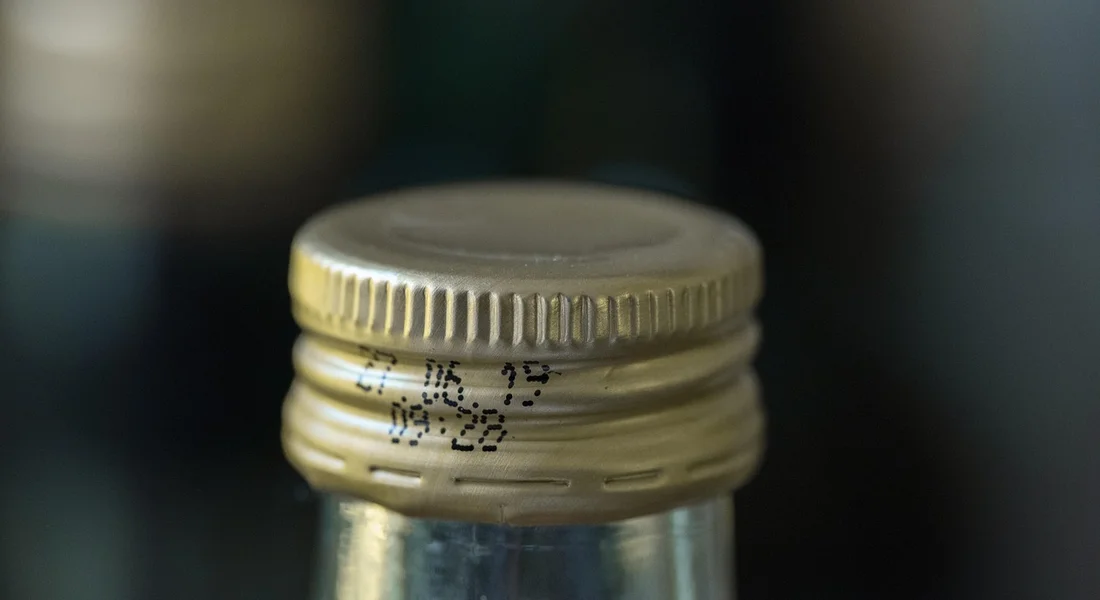 Close-up of a metal bottle cap on a glass bottle, symbolizing everyday hydration.