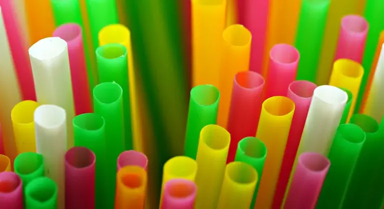 Close-up of bright, colorful plastic straws standing upright