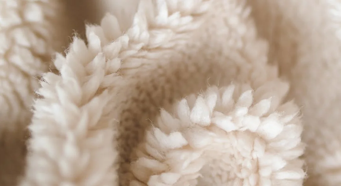 Close-up photo of cream-colored, fluffy fleece fabric