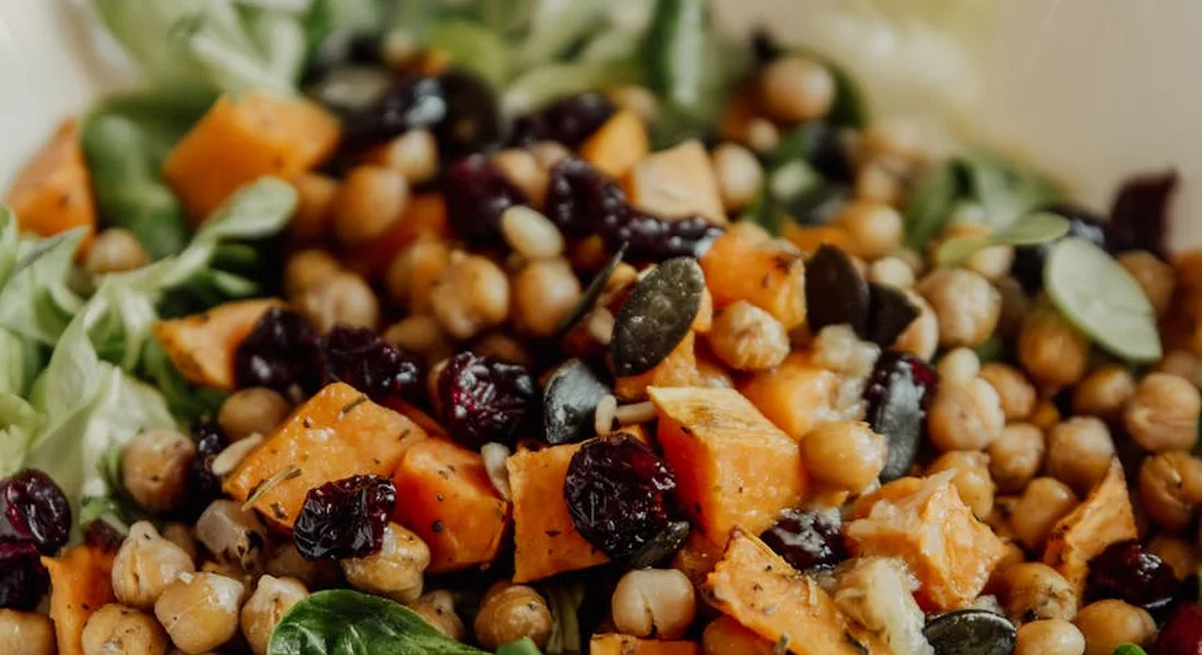 A colorful bowl of chopped vegetables, greens, and seeds, representing a prepared foraged-food mix.