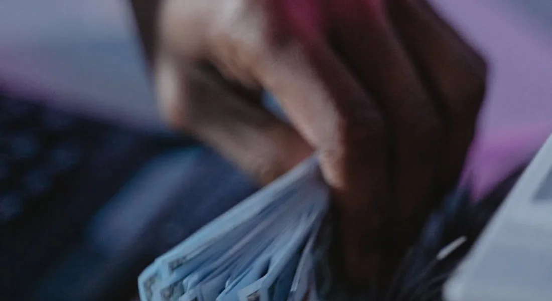 Close-up of hands counting a stack of cash