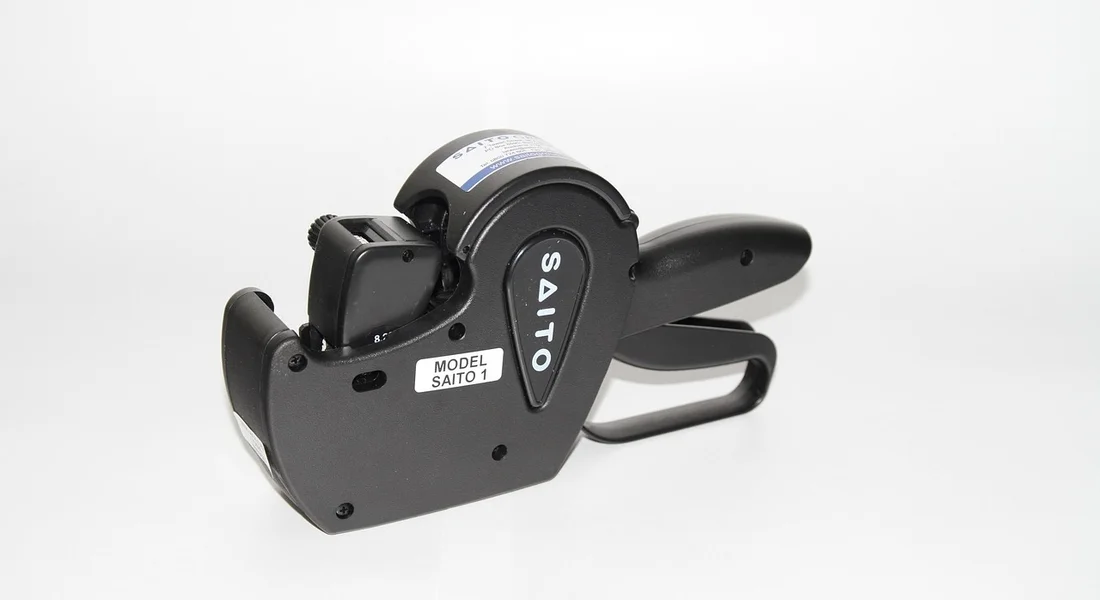 Close-up of a black handheld labeling applicator on a white background