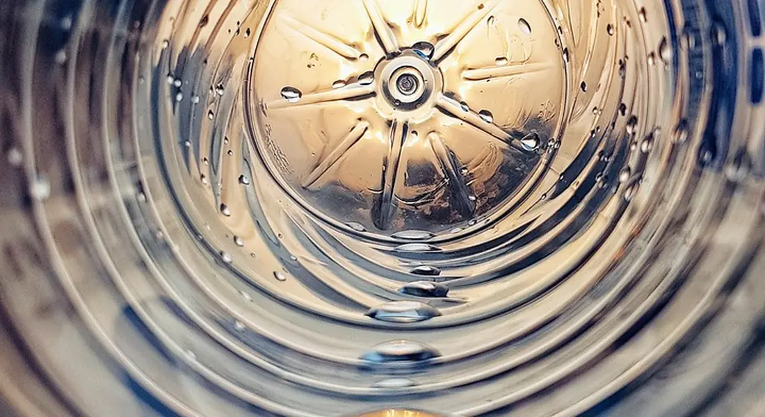 Close-up of the inside of a metal guinea pig water bottle, showing reflective surfaces and ridges.