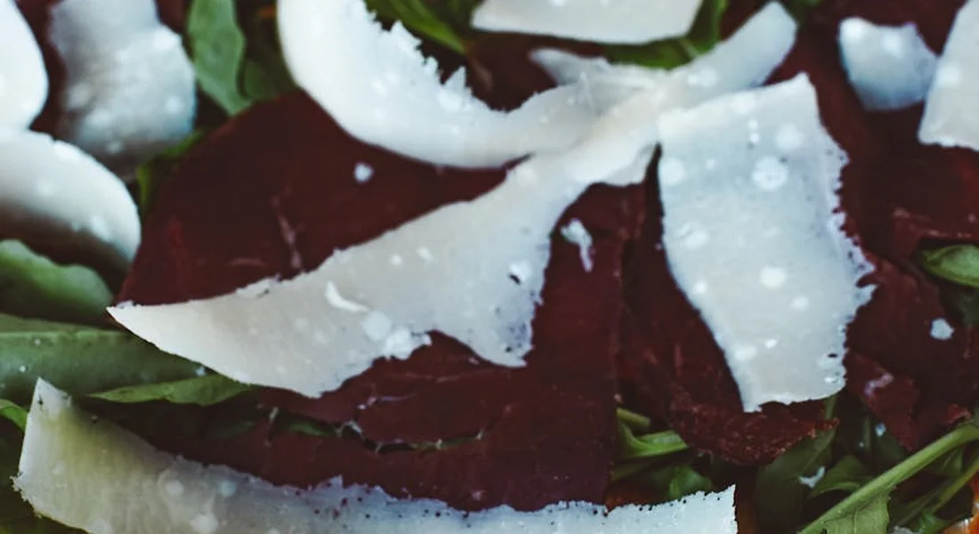 Close-up of arugula leaves with white cheese shavings