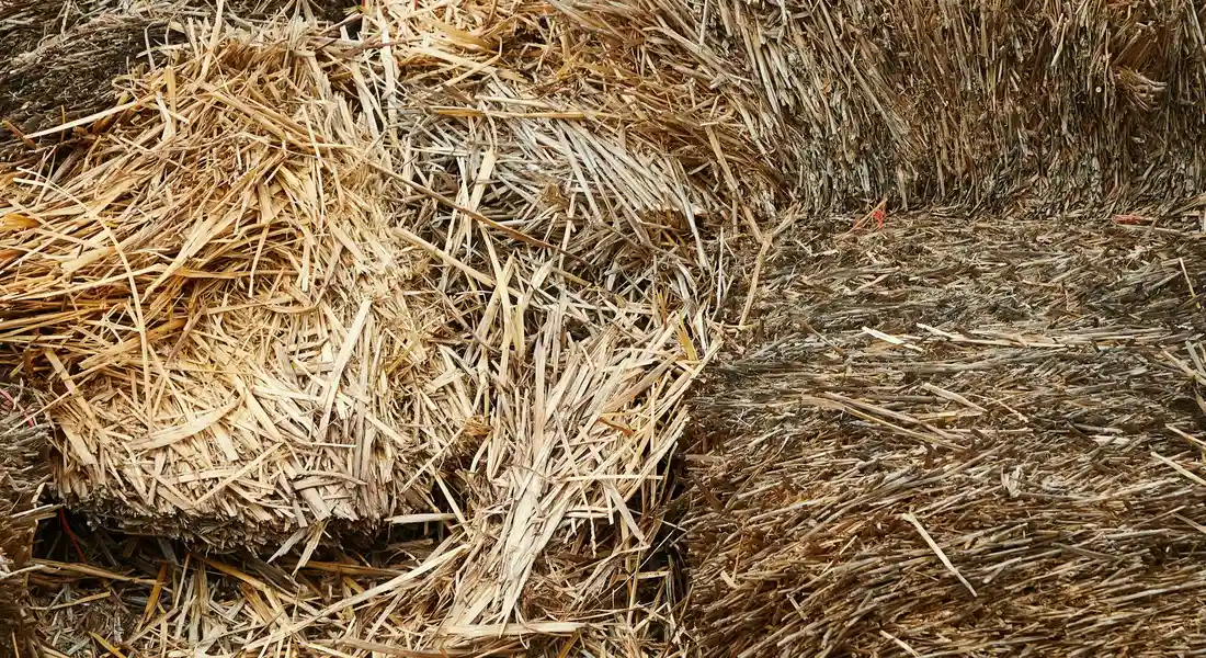 Close-up of stacked hay bales and straw in brown tones