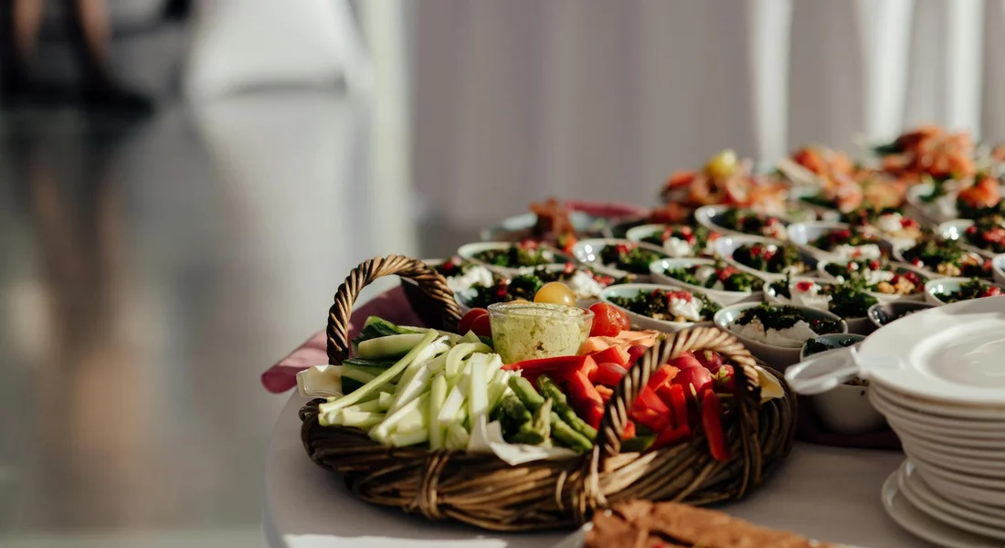 Basket of fresh celery sticks and assorted vegetables on a table, illustrating safe, varied produce for a guinea pig's diet.