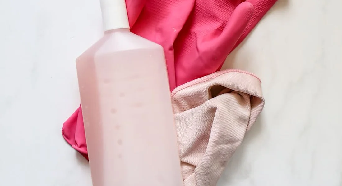 Pink cleaning bottle with a pink cloth and gloves, illustrating the use of diluted, natural cleaners for guinea pig cages