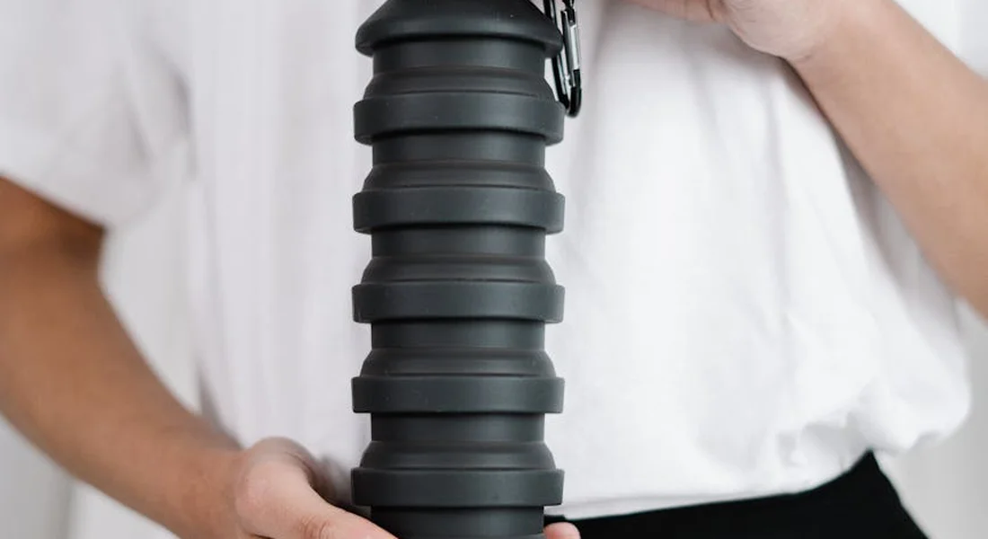 Close-up of a person holding a black ribbed water filtration cartridge, representing alternative water sources for guinea pigs.