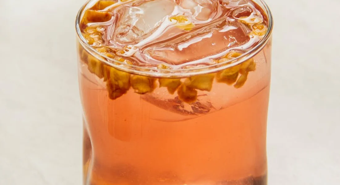 Glass of hibiscus tea with floating flower petals