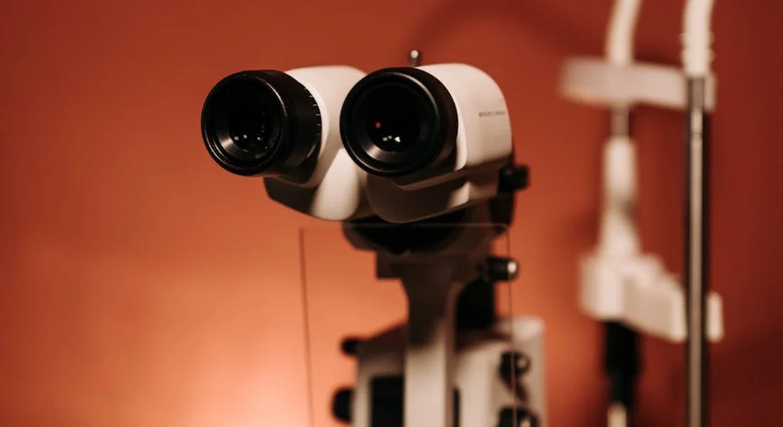 Close-up of a veterinary binocular ophthalmoscope mounted on a stand, used for eye examinations.