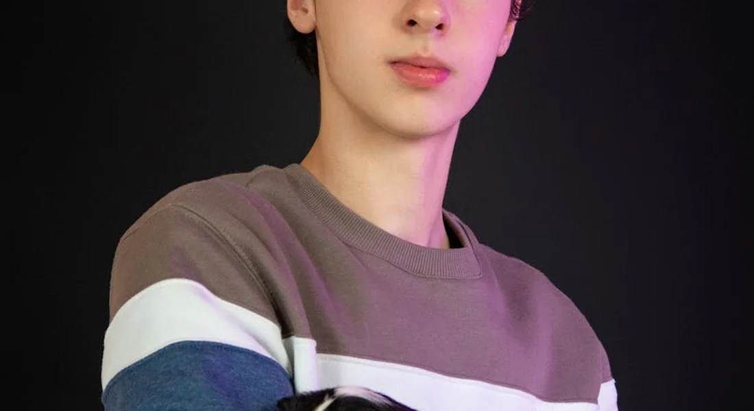 Close-up portrait of a person wearing a brown, white, and blue striped sweater