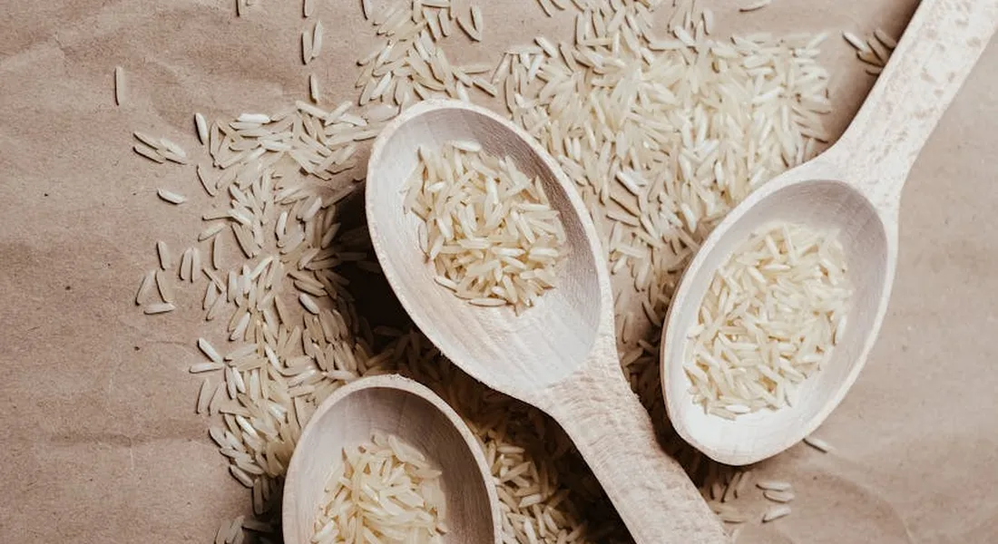 Wooden spoons filled with tiny seeds on a brown kraft paper background.