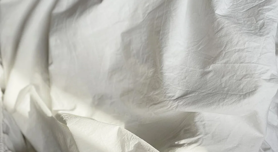Close-up of soft white bedding fabric