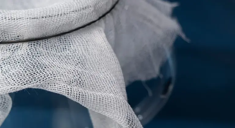 Close-up of white mesh fabric against a blue background.